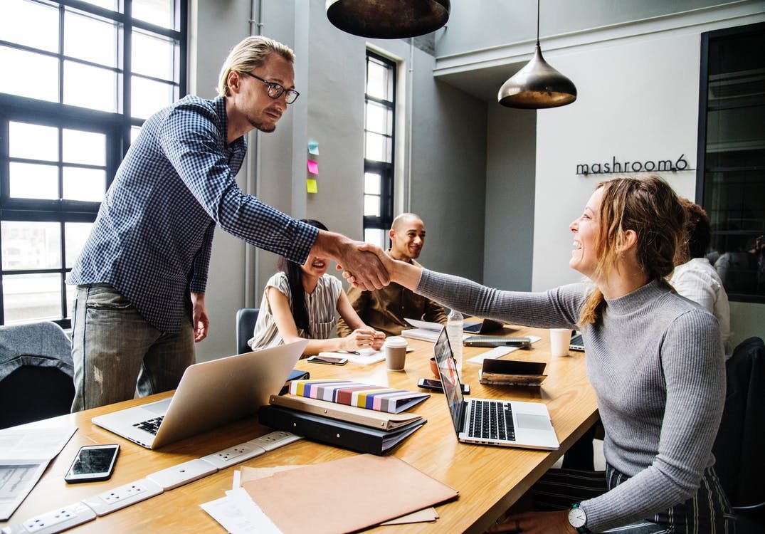 Man and Woman Shake Hands Inside Room